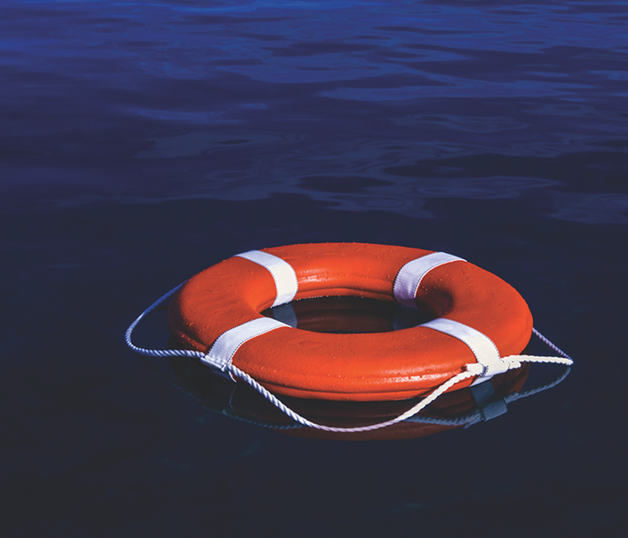 Orange and white Life ring floating in the water.